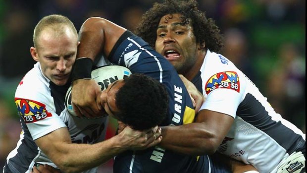 Adam Blair of the Storm is dumped by Darren Lockyer and Sam Thaiday.