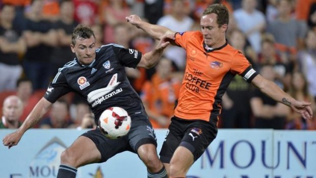 Tough night: Sebastian Ryall (left) clashes with Brisbane's Matt Smith in the Roar's 4-0 win in round two.
