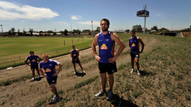 Western Bulldog Ben Hudson (second right) and teammates at the Whitten Oval hill where the club wants to build community and social housing.