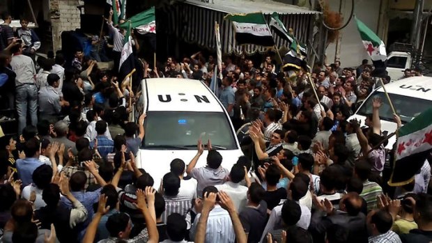 A United Nations observer vehicle is surrounded by a crowd of demonstrator protesting against the regime of Bashar al-Assad.