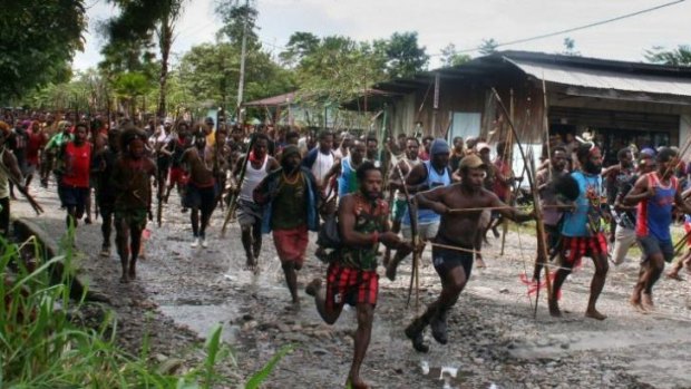 Long-running conflict: Members of the Dani tribe run with bows, arrows and spears in Mimika, Papua in 2006.