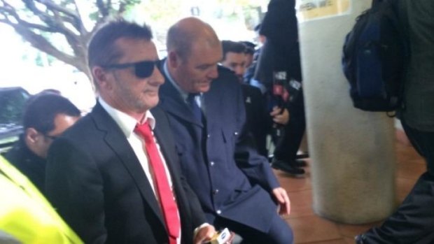 Phil Rudd arrives at court and pleads guilty to threatening a former security guard.