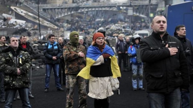 Protesters sing the Ukrainian national anthem at the square on February 22.