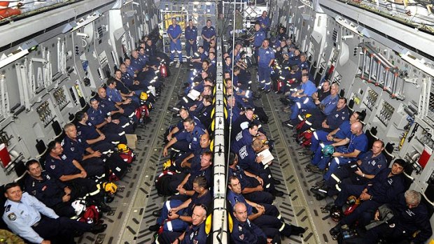 Help on the way: Members of the Australian disaster assistance response team aboard an RAAF C-17 Globemaster en route to Yokota airbase in Japan.