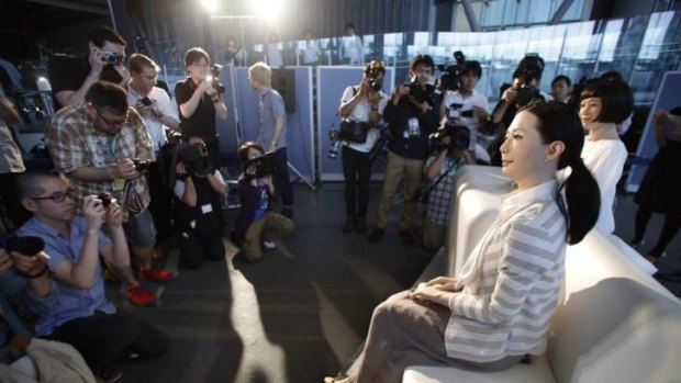 The new face of newsreaders? Photographers gather around female-announcer robot called Otonaroid, second right, and a girl robot called Kodomoroid, right.