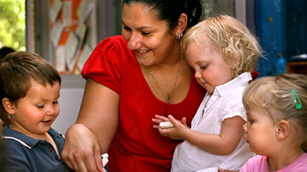 Child-care assistant Bia Tralci looks after Xavier, Lucy and Zoe, all 2, at the Annie Dennis Children's Centre in Northcote.
