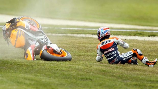 Lucky escape ... Former world champion Casey Stoner looks back as his motorcycle lands safely behind him after crashing during practice yesterday for his farewell Australian MotoGP.