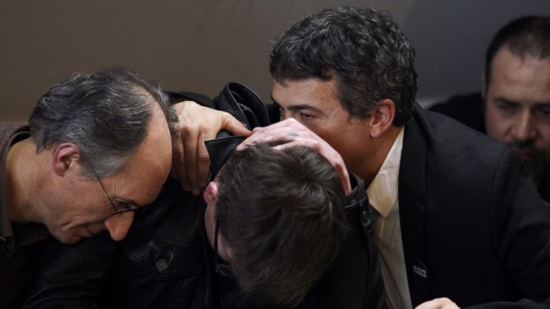 French cartoonist Renald Luzier (centre) is comforted by Charlie Hebdo Editor-in-Chief Gerard Briard (left) and editorialist Dr Patrick Pelloux, during a press conference to present the new issue at the offices of French newspaper Liberation in Paris.