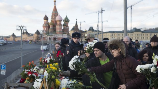 People lay flowers at the place where Boris Nemtsov was gunned down.