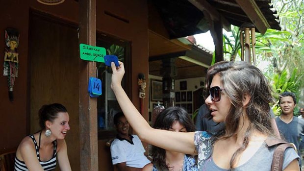 A tourist picks up her number for a fortune telling session Ketut Liyer.