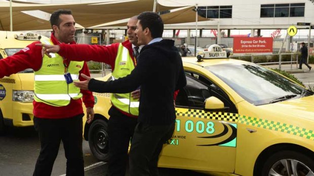 A taxi driver exchanges words with security at Melbourne Aipport.