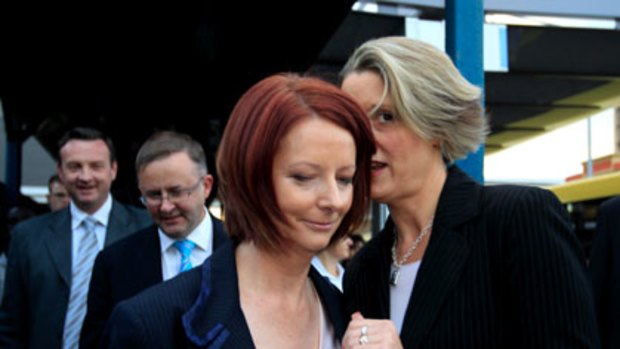 Premier Kristina Keneally has a words in Julia Gillard’s ear.