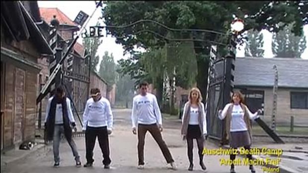 Dancing at Auschwitz in front of the 'Arbeit macht frei' (work sets you free') sign.
