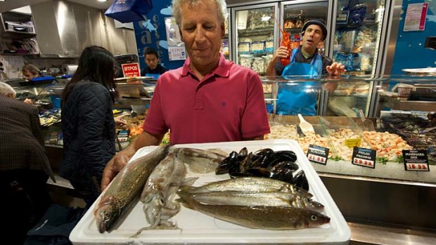 Commercial fisherman John Manias displays sustainable seafood including trout, calamari and mussels  at the Queen Victoria Market.