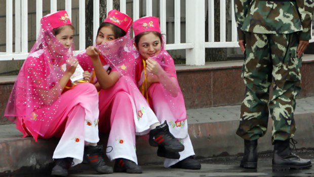 Cheerleaders wait for the start of the Xinjiang leg of the Olympic torch relay in the regional capital Urumqi. Heavy security was in place, with police restricting movement in the city.PICTURE: REUTERS