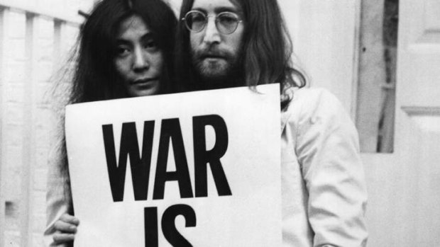 Yoko Ono and John Lennon in 1969 London, holding their 'War Is Over, If You Want It' poster.