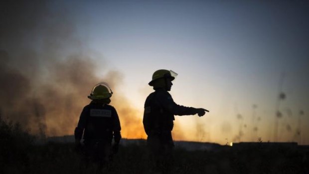 Israeli firefighters monitor a fire caused by a rocket fired from the Gaza Strip by Palestinian militants, near the Israeli southern city of Sderot on Thursday.