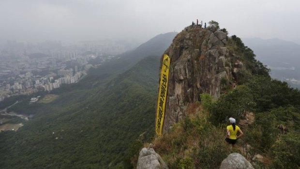 Climbers unfurl the banner high above Hong Kong.