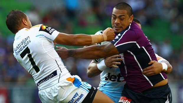 Sika Manu of the Storm is tackled by Scott Prince.