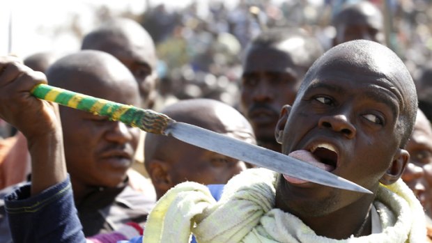 A protestor licks his spear outside the Marikana platinum mine.