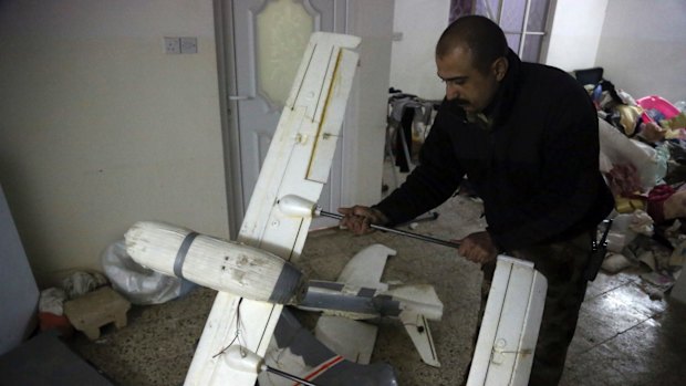 An Iraqi officer inspects drones belonging to Islamic State militants in Mosul, Iraq. 