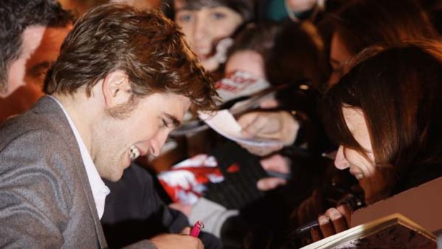 British actor Robert Pattinson signs autographs as he arrives on the red carpet for the UK premiere of Remember Me.