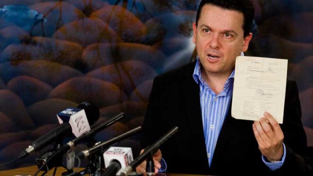 Senator Nick Xenophon shows his deportation notice to the media at Tullamarine Airport after being deported from Malaysia.