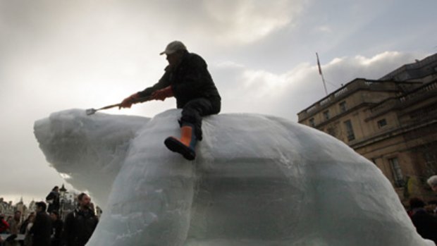 Global warming stripped bear... animal sculptor Mark Coreth sits on his giant ice polar bear in Trafalgar Square to symbolise the threat of climate change to the Arctic.