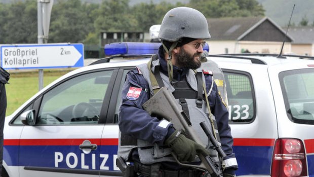 Police stand guard near the villages of Grosspriel and Kollapriel some 90 kms west of Vienna, Austria, on Tuesday, during the farm building  siege.