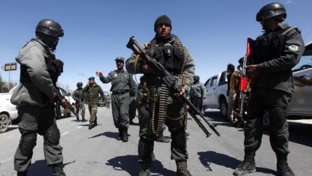Armed response: Afghan police stand guard near the scene of the attack.