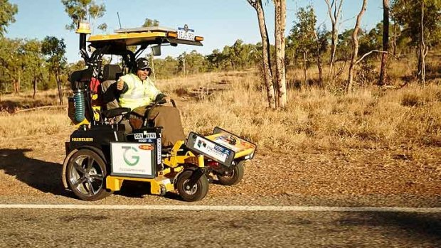 Mr Alford on the lawnmower as he made his way through Hughenden in Queensland
