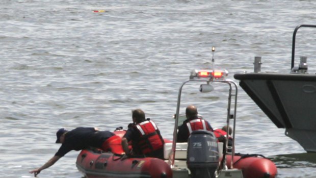 Emergency workers look for debris and possible survivors in the Hudson River after a small plane collided with a tour helicopter carrying about a half-dozen people.
