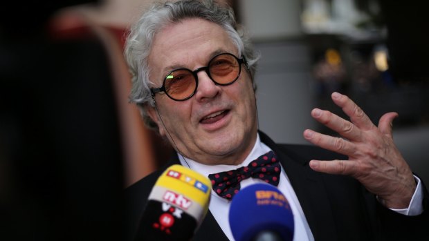 Jury Director George Miller greets reporters as he arrives at the festival. 