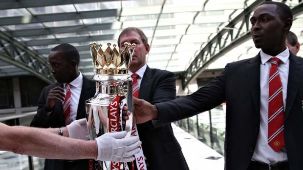 Spoils of victory: Andy Cole (right), flanked by Dwight Yorke and Bryan Robson, gets a hand on the English Premier League trophy he last touched in 2001.