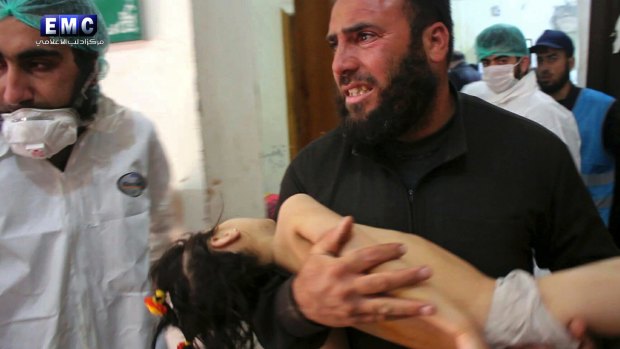 A man carries a child following the suspected chemical attack in the town of Khan Sheikhoun.