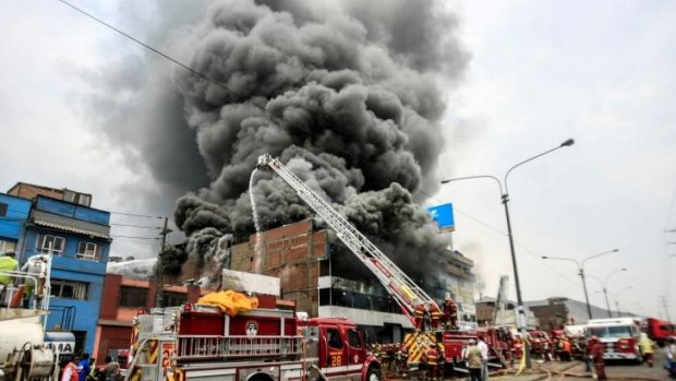 Ablaze: Firefighters attempt to control the fire at a tyre warehouse in downtown Lima.