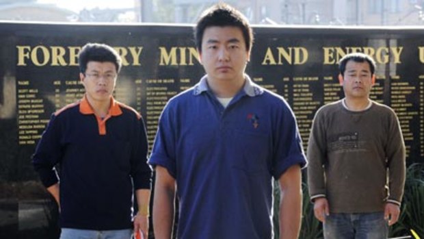 Unpaid...union spokesman Yu Lei Zhou, centre, with Raymond Xing, left, and Gu Lian Chen.