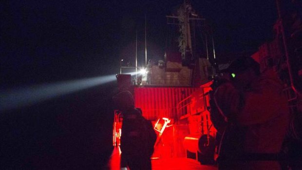 Crew members of the Australian Navy ship, HMAS Success, use a spotlight as they look for debris in the southern Indian Ocean.