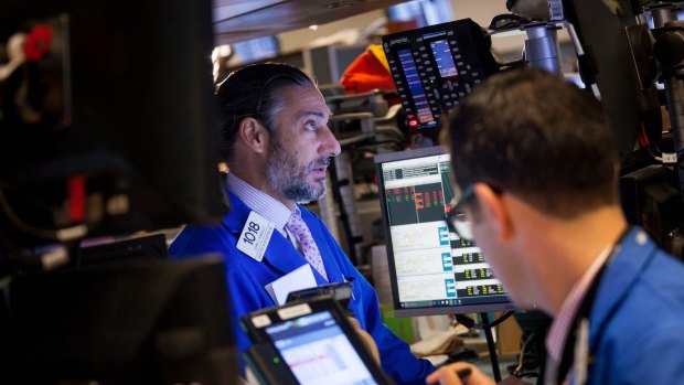 Traders on the floor of the New York Stock Exchange: Shares pared early losses after the deal frenzy set in.
