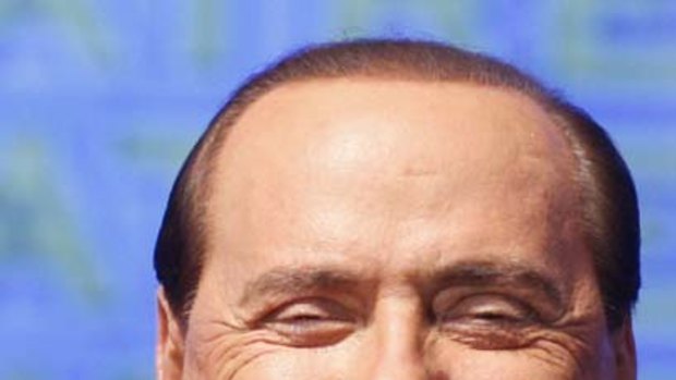"Better than being gay" ... Silvio Berlusconi gestures during a right-wing youth party meeting in September.