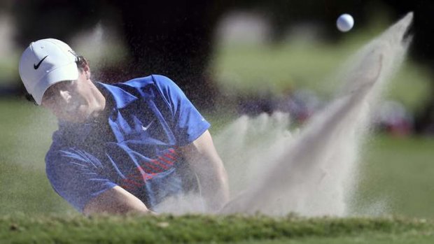 Rory McIlroy digs himself out of the sand.