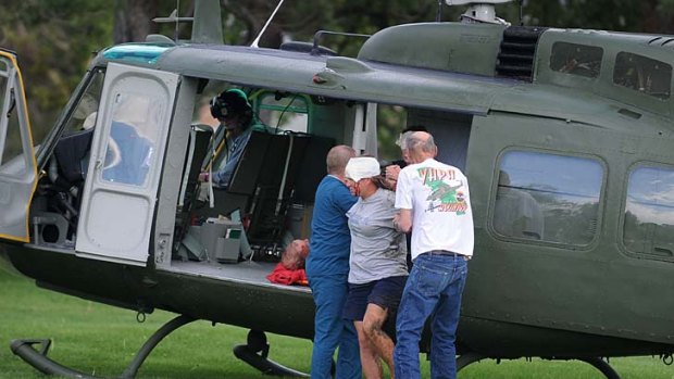 Medics help injured bystanders out of a helicopter into a medical after a plane crashed into the crowd at the Reno National Championship Air Races.