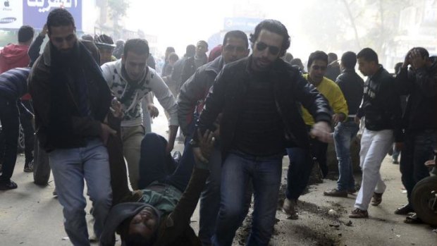 Demonstrators carry an injured Muslim Brotherhood supporter who was shot during clashes in Cairo.