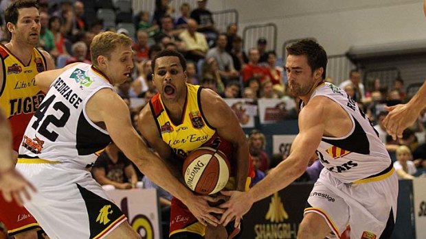 Squeeze: Patty Mills tries to get through the Wildcats' defence.