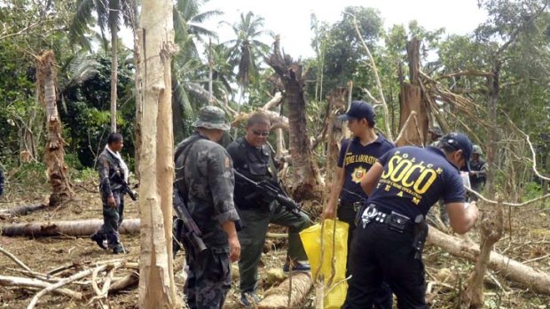 Philippine National Police Special Action Forces and SOCO (Scene of the Crime Operatives) investigators examine the site on the island province of Jolo in southern Philippines.