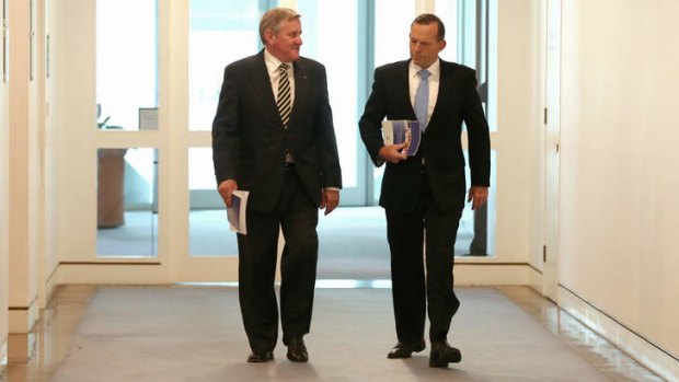 Industry Minister Ian Macfarlane and Prime Minister Tony Abbott arrive for a joint press conference at Parliament House.