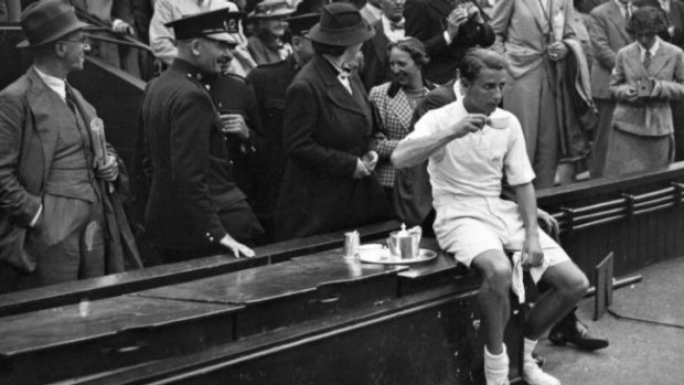 Henry Wilfred 'Bunny' Austin of Greaqt Britain drinks tea after being defeated by Donald Budge during the Davis Cup match at Wimbledon in 1937.