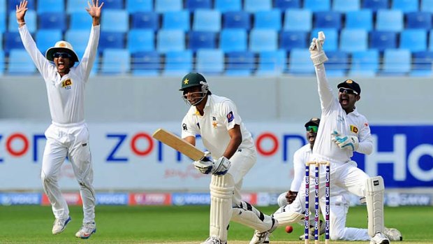 Sri Lankan wicketkeeper Prasanna Jayawardene (right) and teammate Dinesh Chandimal (left) celebrate as Pakistan tailender Rahat Ali is trapped lbw by Rangana Herath (not in picture).