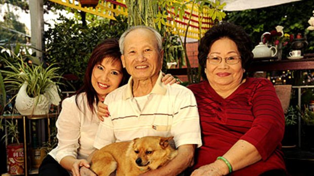 Julie Huynh with her father Minh Huynh, mother De Chung and their dog Simba at the parents' home in Northcote.