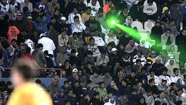 A laser light beams from fans in the stand at Kuwait City today.